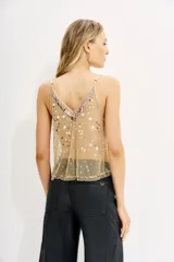 Top de tul negro, transparente, con escote en V ribeteado en satén negro y bordado a mano con lentejuelas y cuentas en tonos dorados, plateados y blancos. Posee breteles finos regulables.