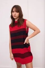 Vestido corto de punto color negro con detalles plateados, cuello alto y sin mangas.