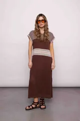 Vestido largo tejido color marrón con rayas horizontales beige y blancas en la parte superior, detalle calado en la parte inferior y tajos a los costados.