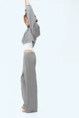 Pantalón deportivo gris de corte recto, con cintura elástica y bolsillos laterales.