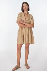 Vestido corto celeste de lino, con cuello tipo polo con detalle de puntilla, mangas cortas y falda escalonada con volantes.