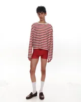 Remera manga larga de viscosa con estampado de rayas horizontales rojas y blancas. Tiene corte a la altura de la cadera y cuello con puño de algodón.