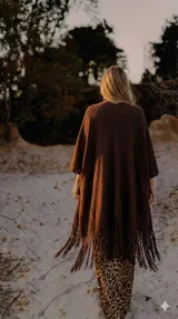 Ruana color crudo de tejido artesanal con flecos largos en el ruedo.