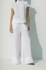 Pantalón blanco de lino, de corte palazzo y cintura con cordón ajustable.