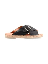 Sandalias negras de cuero con tiras cruzadas y hebilla dorada.