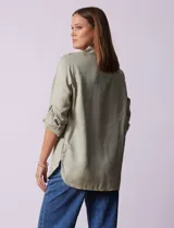 Camisa verde claro de tencel, marca Hester & Orchand. Cuello con solapa, escote en V y abertura central con botones. Delantera con bolsillos. Largo de manga regulable con presilla y botón.