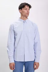 Camisa de vestir de hombre, de corte clásico, con cuello abotonado y bolsillo en el pecho. Diseño a rayas verticales celestes y blancas.