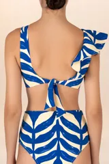 Top de bikini con estampado de ondas fluidas en azul y blanco, con volado en un lado, escote en V y amarre con coletas en la espalda.