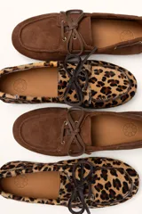 Mocasines náuticos de cuero color marrón, con cordones de cuero y suela de goma.