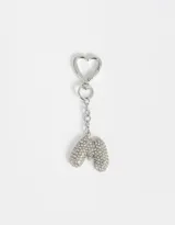 Llavero plateado con dije de la letra M cubierto de strass y gancho con forma de corazón.