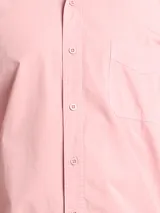 Camisa de manga larga color verde oliva, confeccionada en algodón. Tiene corte clásico, bolsillo en el lado izquierdo del pecho y cierre con botones.