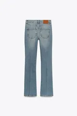 Pantalón de jean azul oscuro, de tiro bajo, corte slim fit y bootcut. Con cinco bolsillos y cierre frontal con cremallera y botón.