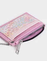 Tarjetero de cuerina color lila con estampado floral, cierre superior con cremallera y doble bolsillo frontal. Incluye mosquetón metálico para colgar.
