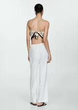 Pantalón de lino blanco, de corte recto, con cintura elástica y lazo de ajuste.