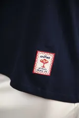 Remera azul marino de algodón con cuello redondo blanco y mangas cortas con bordado blanco.