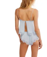 Conjunto de ropa de descanso de dos piezas, color negro, compuesto por un camisola con tirantes finos y un short. Ambas piezas son de encaje floral transparente y tienen detalles de ribete festoneado.