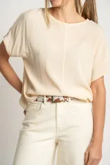 Blusa color crema de poliéster con mangas cortas y corte holgado.