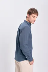 Camisa de lino azul oscuro de corte clásico, con cuello abotonado y bolsillo en el pecho.