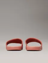 Ojotas color salmón con logo Calvin Klein Jeans en blanco.