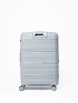 Valija rígida de viaje color gris con diseño de líneas horizontales. Cuenta con manija extensible, cuatro ruedas con giro de 360°, cierre con combinación y manija lateral.