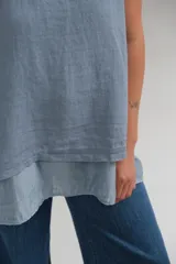 Musculosa celeste de lino italiano con cuello redondo, ruedo de doble largo y abertura en la espalda.