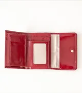 Billetera plegable color azul con textura de cuero croco y cierre a presión metálico con logo de flor de lis.