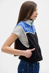 Chaleco negro con la parte superior azul y detalles geométricos en blanco.