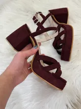 Sandalias de plataforma color vino con tiras cruzadas y tobillera con hebilla.