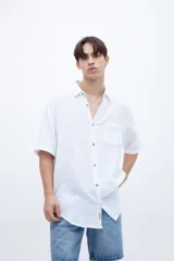 Camisa blanca de manga corta con cuello solapa clásico, bolsillo en el pecho y botones personalizados.