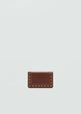 Billetera marrón de efecto piel con detalle de tachuelas doradas. Tiene múltiples ranuras para tarjetas, bolsillo interior con cierre de cremallera y compartimento central para billetes. Cierre de solapa con botón a presión.