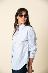 Camisa de manga larga a rayas verticales color violeta y blanco, con cuello clásico y corte recto.