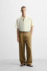 Camisa de hombre relaxed fit con cuello bowling y manga corta, confeccionada en tejido fluido con mezcla de viscosa a rayas verticales en tonos verde y blanco.