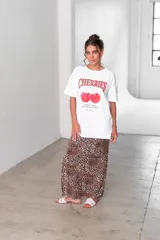 Conjunto que incluye camiseta blanca con estampado de cerezas y pollera larga de viscosa, con diseño animal print.