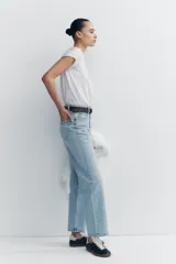 Pantalón de jean celeste de tiro alto, corte recto, con cinco bolsillos y cierre frontal con cremallera y botón metálico.