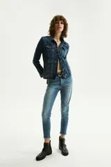 Pantalón de jean de tiro alto, corte slim, color celeste claro, con rotura en la rodilla y terminación desflecada en el tobillo.