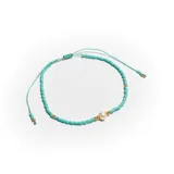 Pulsera ajustable de cuentas turquesas y detalles dorados, con una perla central.