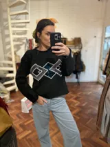 Sweater color crema de tejido de punto con cuello redondo y apliques geométricos metálicos bordados a mano en el frente.