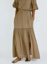 Pollera larga color crudo, de corte amplio y con volados.