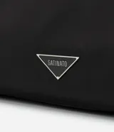 Cartera hobo grande color negro, confeccionada en poliéster y poliuretano. Cuenta con cierre de botón a presión, separadores con cremallera, bolsillo externo, asa mediana ajustable contrastante y detalle triangular de metal.