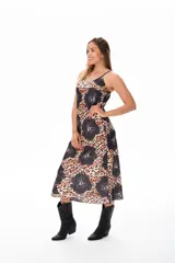 Vestido midi con estampado animal print y flores negras, de breteles finos y corte suelto.