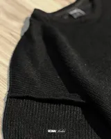 Buzo color crema de lana premium con textura acanalada y costuras expuestas.