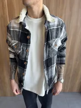 Chaqueta de paño a cuadros blancos y negros con interior de corderito blanco.