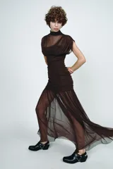 Vestido midi marrón con cuello alto y sisas. Presenta detalle de tejido combinado y drapeado. Tiene tirantes finos ajustables y cierre lateral con cremallera oculta.
