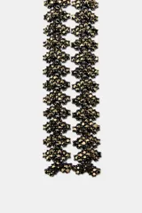 Collar largo tipo corbata con múltiples piezas metálicas y aplicación de brillos a contraste. Cierre con mosquetón.