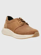 Sneakers marrones de cuero con cordones y suela blanca texturizada.