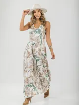 Vestido largo de tirantes finos con estampado floral en tonos beige y verde.