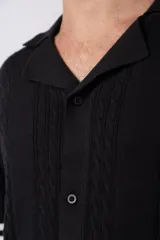 Camisa de tejido de punto color beige, con cuello tipo bowling, manga corta y corte relajado. Cierre frontal con botones.