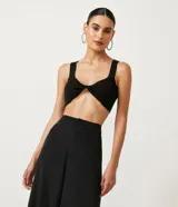 Musculosa cropped de punto negro con escote redondo y busto retorcido.