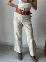 Pantalón de vestir color crudo con bordado floral blanco.