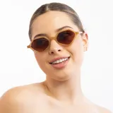 Lentes de sol con marco geométrico color miel y lentes marrones degradé.